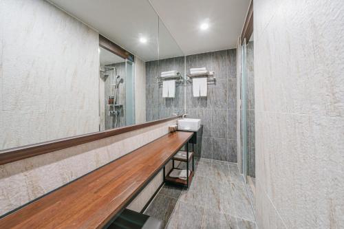 a bathroom with a sink and a mirror at Hotel With City in Jeju