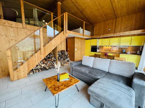 a living room with a couch and a table at Chalet Breithorn- Perfect for Holiday with Amazing View! in Obergesteln