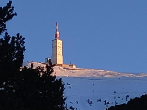 um farol no topo de uma ilha na água em Chalet d'argençon em Mont Serein