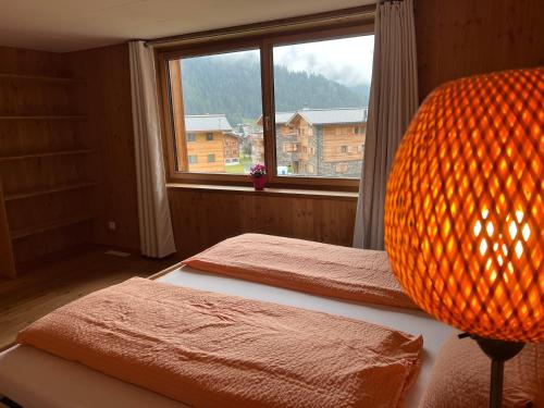 a bedroom with two beds and a large window at Chalet Breithorn- Perfect for Holiday with Amazing View! in Obergesteln