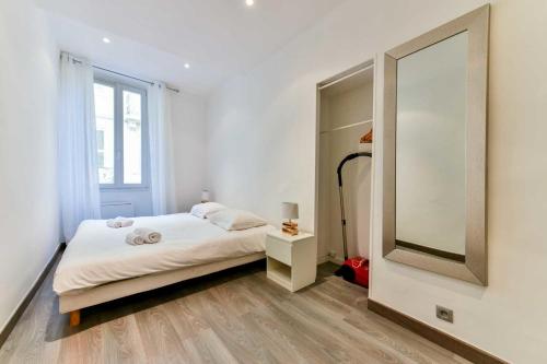 een slaapkamer met een bed en een grote spiegel bij CMG - Bel appartement - 5 min à pied du Palais des Festivals in Cannes