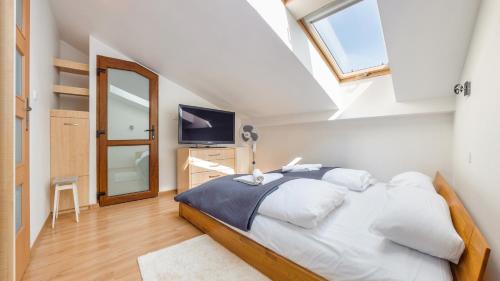 una camera da letto con un letto con lenzuola bianche e una finestra di Hołdu Pruskiego, Sun & Snow a Świnoujście