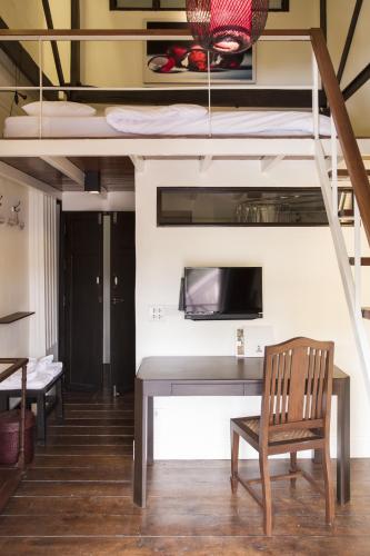 a room with a desk and a bunk bed at Baan Luang Rajamaitri Historic Inn in Chanthaburi