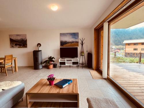 - un salon avec un canapé et une télévision dans l'établissement Chalet Breithorn- Perfect for Holiday with Amazing View!, à Obergesteln