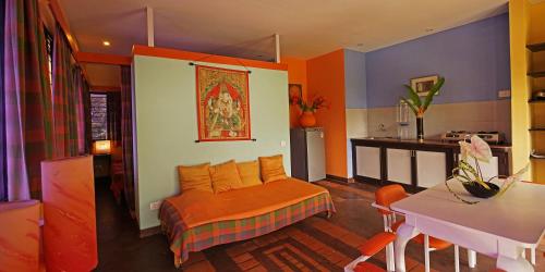a bedroom with a bed with an orange blanket at Auromode Apartments Auroville in Auroville