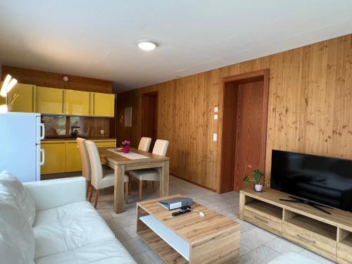 a living room with a white couch and a kitchen at Chalet Breithorn- Perfect for Holiday with Amazing View! in Obergesteln