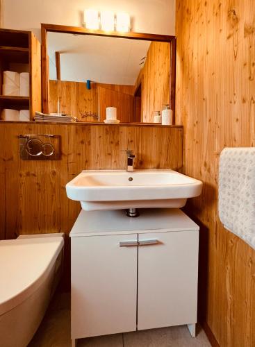 a bathroom with a sink and a toilet and a tub at Chalet Breithorn- Perfect for Holiday with Amazing View! in Obergesteln