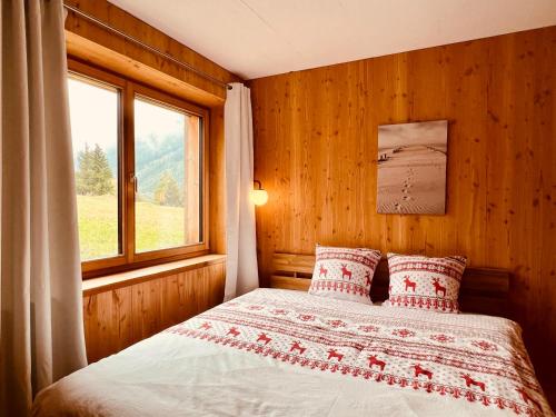 a bedroom with a bed with a window at Chalet Breithorn- Perfect for Holiday with Amazing View! in Obergesteln