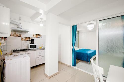 una piccola cucina bianca con un letto blu dentro di Panorama Dunarii a Galaţi