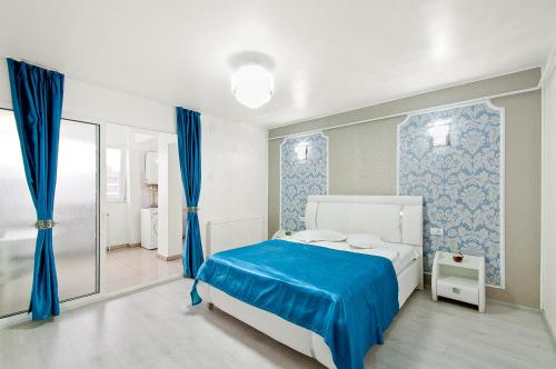 Un dormitorio con una cama azul y blanca y un baño. en Panorama Dunarii, en Galaţi