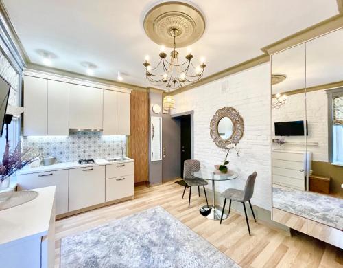 a kitchen with a table and chairs and a chandelier at Daugavpils Delux in Rīga