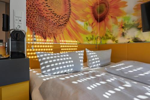 um quarto com uma cama com um quadro de girassóis em Buddy Hotel em Munique