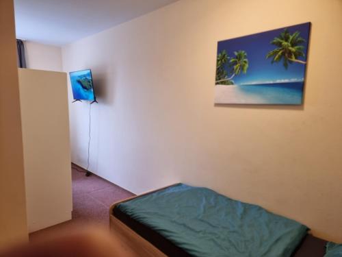 Zimmer mit einem Bett und einem Bild an der Wand in der Unterkunft Onkel Tom Amazonien & Ozeanien in Paderborn