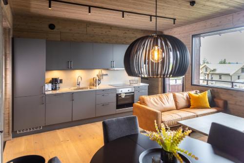 cocina y sala de estar con sofá y mesa en Mosetertoppen Skiline - Hafjell Ski Resort, en Øyer
