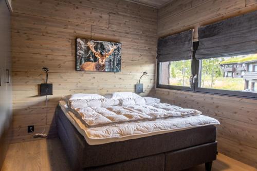 a bedroom with a bed in a room with wooden walls at Mosetertoppen Skiline - Hafjell Ski Resort in Øyer