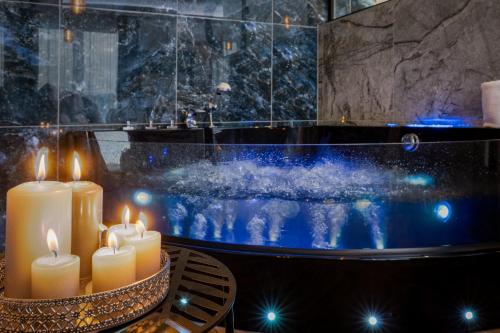 a group of candles sitting on a table in front of a tub at Stacja Galicja Rooms blisko Energylandia in Trzebieńczyce