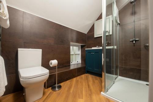 a bathroom with a toilet and a shower at Lock Keepers Cottage, Loch Ness Cottage Collection in Inverness