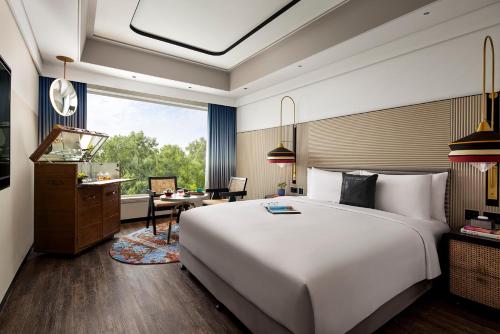 a bedroom with a large white bed and a desk at Hyatt Centric Sector17 Chandigarh in Chandīgarh