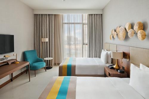 Postel nebo postele na pokoji v ubytování Holiday Inn Dubai Al-Maktoum Airport by IHG