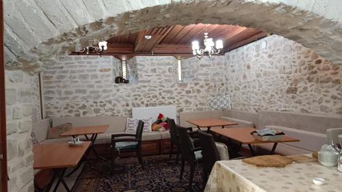 a dining room with tables and chairs and a stone wall at Çamlıca Konak Çarsı in Safranbolu