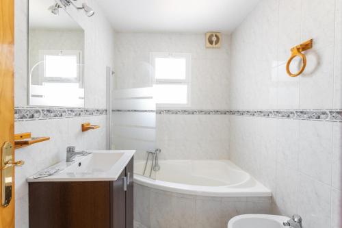 a bathroom with a tub and a sink and a toilet at Villa Benama in Torrox