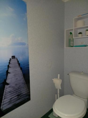 baño con aseo y una foto de un muelle en Charmant logement sur la station de Val Louron en Val Louron