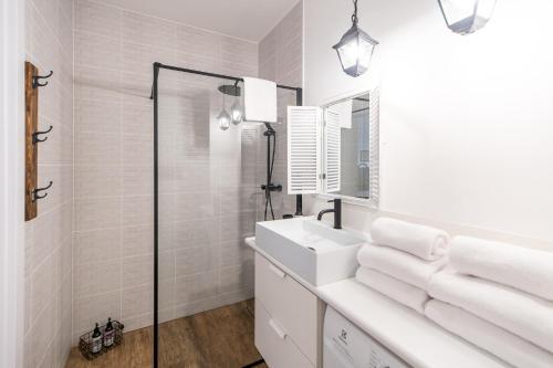 a white bathroom with a sink and a mirror at Apartament WOOD SurfingBird Dźwirzyno in Dźwirzyno