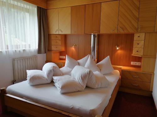 Un dormitorio con una cama con almohadas blancas. en Haus Bellevue, en Längenfeld