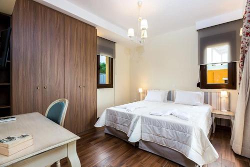 Family villa, Fantastic views, Private pool, Free laptop 1 في Roúpai: غرفة نوم بسرير ابيض كبير وطاولة