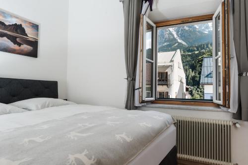 a bedroom with a bed and a large window at Central-Inn Werfen in Werfen