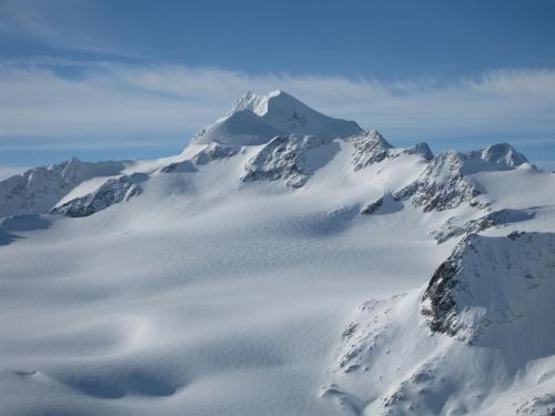 a mountain covered in snow and clouds in the sky at Hotel Neue Post in Sölden