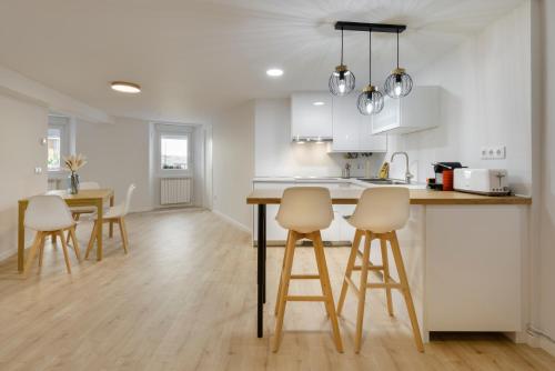a kitchen with white cabinets and a table and chairs at Alojamiento Maite Jaca in Jaca