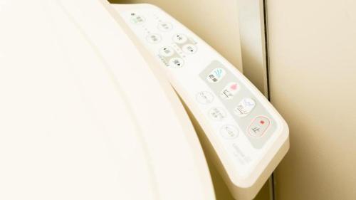 a white remote control attached to a wall at Toyoko Inn Tozai-sen Kiba-eki in Tokyo