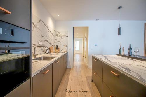 a large kitchen with marble counter tops and a sink at ApartHotel Boutique by Urban Home Stay in Alkmaar