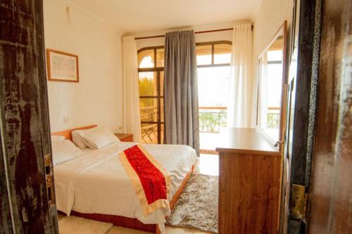 a bedroom with a bed and a window at Elevate Suites Gisenyi in Gisenyi