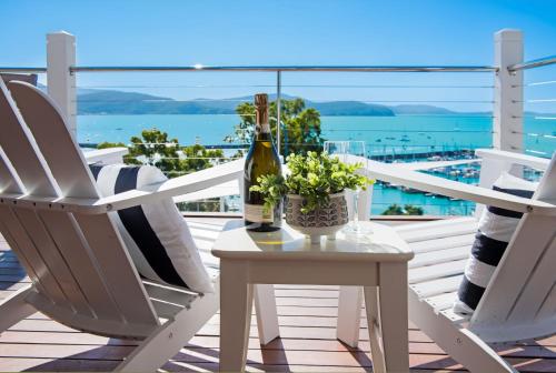 a table with a bottle of wine and two chairs on a balcony at A Point of View in Airlie Beach