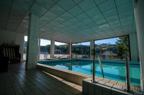 a swimming pool in a building with a view at Hotel Pension Jägerstieg in Bad Grund