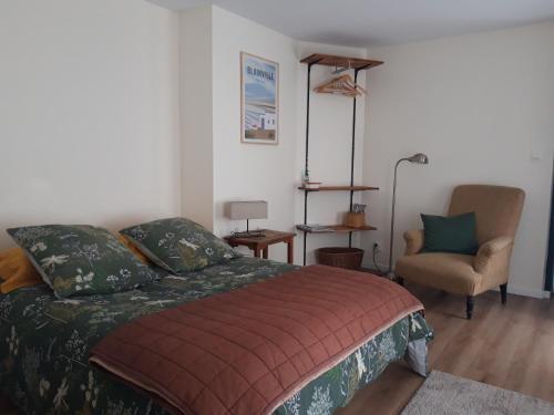 a bedroom with a bed and a chair at Agréables chambres indépendantes - Coutances centre in Coutances