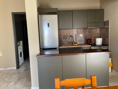 a kitchen with a stainless steel refrigerator and a wooden chair at Lenio’s in Karistos