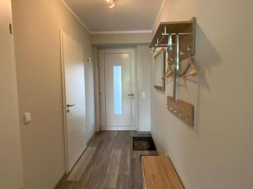 a hallway with a door and a light fixture on a wall at Exclusive apartment on Fehmarn in Petersdorf auf Fehmarn