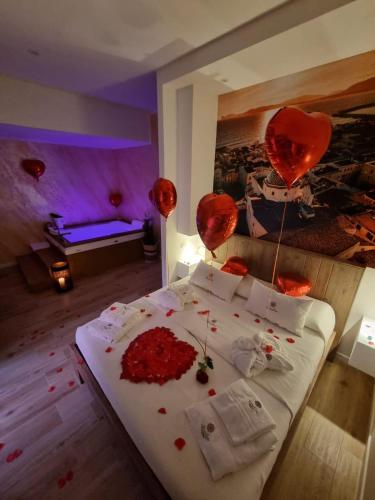 a bedroom with a bed with red hearts and balloons at Sunshine Charming Houses in Alghero