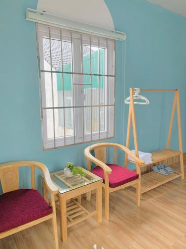a room with two chairs and a table and a window at Mi Casa Homestay in Da Lat