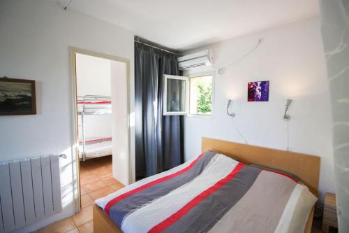 Un dormitorio con una cama en una habitación con ventana. en La Françonne Blanc - Gîte de charme en Provence, en Mirabel-aux-Baronnies