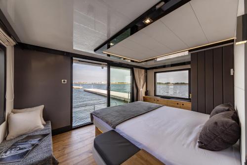 a bedroom with a large bed and a large window at Houseboat Nomadream in Gdańsk