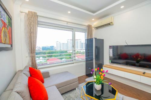 een woonkamer met een bank en een groot raam bij Sumitomo Tower-1 Bed Apartment & Hotel in Hanoi