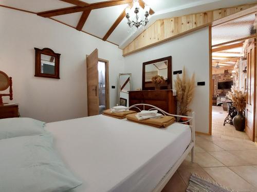 a bedroom with a large white bed and a mirror at House Rustic heaven in Novi Vinodolski