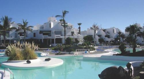 ein Pool in einem Resort mit weißen Gebäuden in der Unterkunft Casa Yuma in Costa Teguise