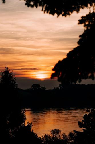 a sunset over a body of water with trees at Kulcs a Szívemhez in Kulcs