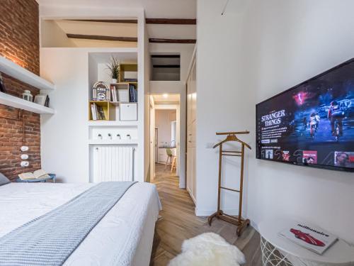 1 dormitorio con 1 cama y TV grande en la pared en Emma's home Monza, en Monza