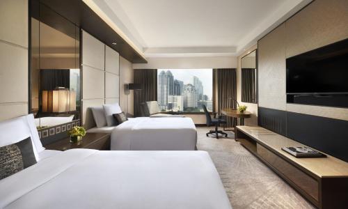 a hotel room with two beds and a television at ARTOTEL Suites Mangkuluhur Jakarta in Jakarta